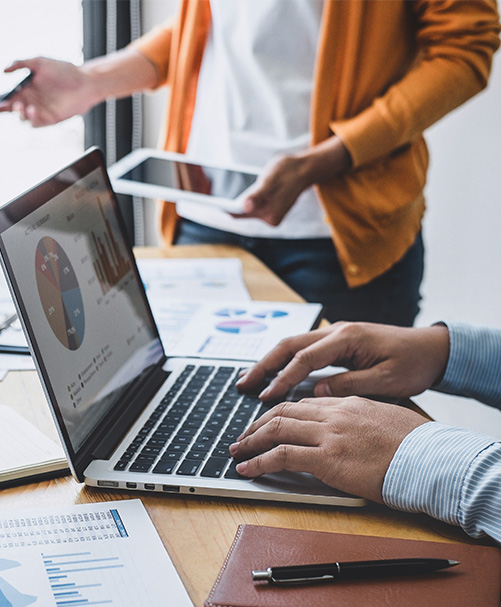 Team members working at conference table on computers