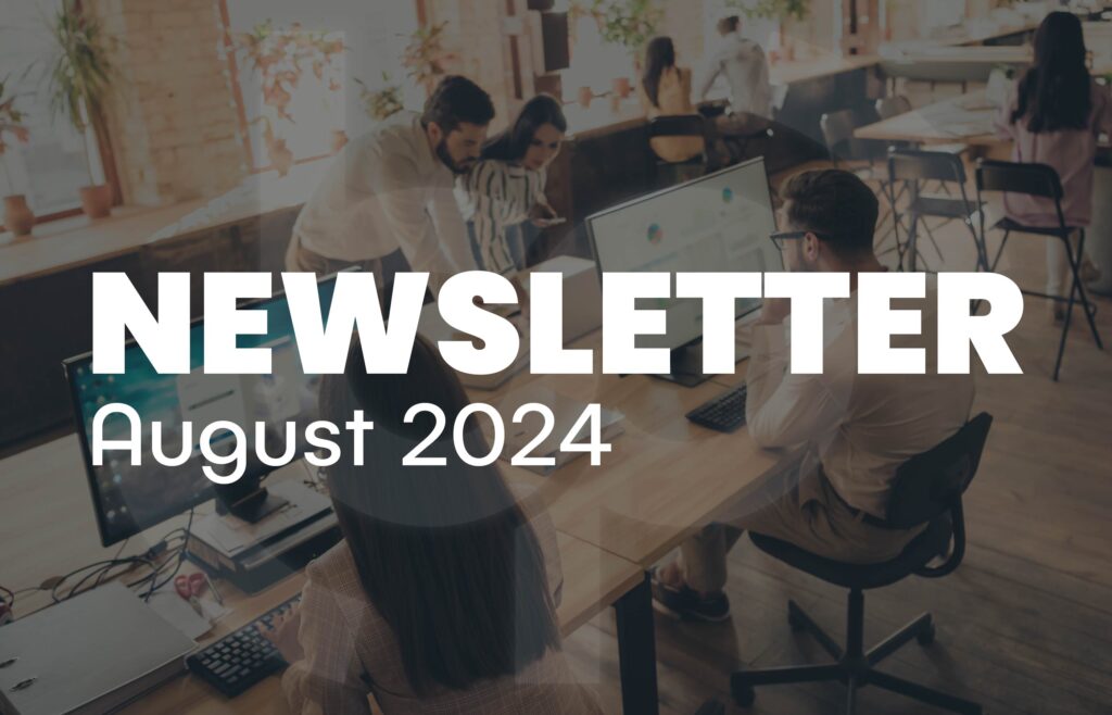 Office scene with team members working together at desks with computers, highlighted by large bold text “NEWSLETTER August 2024” overlaying the image. The office has a modern, collaborative atmosphere with natural light and plants enhancing the workspace. Ideal for illustrating corporate updates, team collaboration, and modern workplace environments. Keywords: newsletter, August 2024, office teamwork, modern workplace, business updates, corporate news.