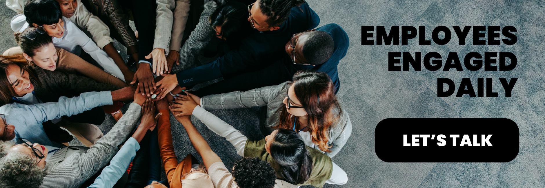 Overhead view of a diverse and enthusiastic team uniting their hands in a group huddle, symbolizing employee engagement, collaboration, and a strong workplace culture powered by HR software from Bennett/Porter for Pacific Northwest businesses.